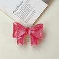 Detailed view of pink glitter bow phone grip stand on minimalist cream tabletop - Large Bow Stand - Cloud Flash Red