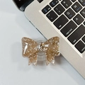 Detail of a brown glitter bow phone grip made of translucent resin on a laptop - Large Bow Grip-Dot Glitter-Caramel