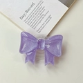 Dettaglio del supporto per telefono a fiocco viola glitterato su sfondo di rivista - Supporto a Fiocco Grande - Viola Scuro Bagliore di Nuvola