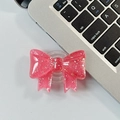 Detail of a pink glitter bow foldable phone grip stand on a gray office desk - Large Bow Grip-Dot Glitter-Rose Red