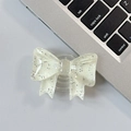 Close-up of a semi-transparent glittery bow-shaped expandable phone socket and stand - Large Bow Grip-Dot Glitter-Cream White
