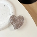Vue détaillée du support de téléphone cœur pailleté avec sequins argentés et fini gris fumé - Grand cœur tordu - Points pailletés / Noir transparent