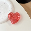 Détail du support de téléphone cœur rouge à paillettes sur un plateau en céramique - Grand cœur tordu - Points pailletés / Rouge Translucide