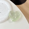 Macro view of a light green glitter heart phone grip with sparkling resin texture - Large Crooked Heart - Glitter Dots / Transparent Green