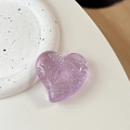 Close-up of a translucent purple heart phone grip with sparkling silver glitter details - Large Crooked Heart - Glitter Dots / Translucent Light Purple