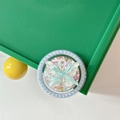 Detalle de un soporte para móvil con lazo azul y lentejuelas de colores en forma de corazón - Estilo Magnético de Perla / Mariposa Azul Colorida