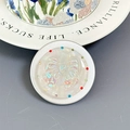 Close-up of a circular MagSafe phone grip with shell texture and rhinestone bow detail - Aurora Pleated Bow