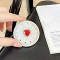 Detailed close-up of a magnetic heart rhinestone phone socket with red crystal on white base - Matte Silver Magnetic - Sweetheart / Red