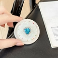 Macro shot of magnetic phone grip with blue heart rhinestone and pearl white shell texture - Matte Silver Magnetic - Sweetheart / Blue