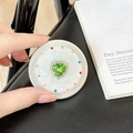 Macro detail of magnetic phone grip with green heart gemstone and colorful rhinestones - Matte Silver Magnetic - Sweetheart / Green