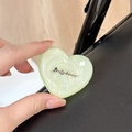 Macro shot of a light green glitter heart phone grip with Lucky Horse metallic logo - Stereo Heart - Light Green Glitter / Adhesive Stand Style