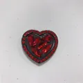 Macro detail of heart-shaped phone ring holder with red rhinestones and black alloy base - Heart Ring / Red