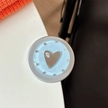 Macro detail of heart-shaped magnetic phone grip with mine text on blue polka dot base - Matte Silver Magnetic - Dopamine Small Heart Mirror / Blue