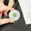 Detailed view of heart-shaped green rhinestone phone grip with pearl shell texture - Transparent Stand - Sweetheart / Green