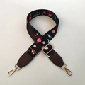 Detail of adjustable wide nylon bag strap featuring space planets and Dream BIG slogan - Brown