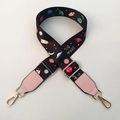 Close-up of adjustable strap with colorful space patterns and gold metal hardware hooks - Pink