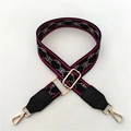 Detail of adjustable wide striped shoulder strap with gold metal buckles for crossbody bags - Red Black Pattern + Black Leather