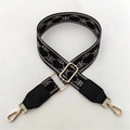 Close-up of wide woven strap with grey geometric pattern and gold-tone lobster clasps - Grey Black Pattern + Black Leather