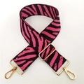 Macro detail of pink and black zebra print bag strap with golden metal swivel hooks - Rose Red