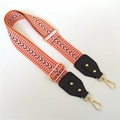 Detail of adjustable orange woven shoulder strap with gold-tone hardware and leather ends - Orange + Black Leather Trim