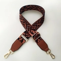 Detail of adjustable wide canvas strap with orange and black geometric weaving and gold clasp - Brown Style with Brown Leather