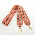 Detail of colorful geometric wave embroidery and gold lobster clasps on the wide bag strap - Orange