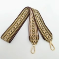 Macro detail of geometric jacquard embroidered bag strap with gold lobster clasps - Khaki