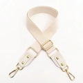 Close-up of cream cotton bag strap with golden metal buckle and lobster hooks - Off White