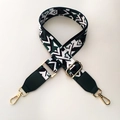 Detail of adjustable wide bag strap with green geometric pattern and gold metal hooks - Black & Green with Green Leather