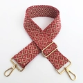 Close-up of red and beige geometric embroidered guitar strap with gold metal lobster clasps - Red