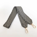 Detail of black and white geometric pattern woven bag strap with golden metal swivel hooks - Black
