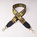 Close-up of ethnic weave bag strap with yellow floral pattern and gold metal hooks - No.9 + Black Leather Trim