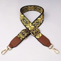Close-up of ethnic woven bag strap with yellow floral patterns and gold metal clasps - No.9 + Brown Leather Trim