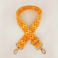 Detail view of ethnic geometric woven pattern on adjustable bag strap with gold metal hooks - Orange & Yellow With Gold Buckle (A14)