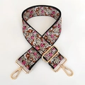 Macro detail of wide embroidered floral bag strap with gold lobster claw metal clasps - Deep Pink
