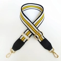 Détail de la bandoulière réglable à rayures avec embouts cuir et crochets dorés - Rayures noires et jaunes