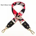 Detail eines rot-silbernen Camouflage-Taschenriemens mit goldenen Metallhaken und Leder - Rot & Silber Metallic
