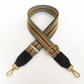 Detail eines verstellbaren gestreiften Schultergurts mit goldenen Metallhaken und Leder - Khaki Gestreift