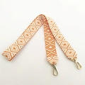 Close-up of bohemian orange and white geometric woven handbag strap with gold swivel hooks - Long Style / Orange