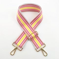 Detail of adjustable woven bag strap with colorful red and grey stripes and gold hardware - Pink / Silver Clasp