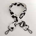 Close-up of leopard print nylon bag strap with gunmetal swivel hooks and adjustable buckle - White Silver Line + Gunmetal Buckle
