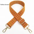 Detail of yellow brown houndstooth bag strap with adjustable gold-tone metal buckles - Tan