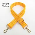 Close-up of bright yellow houndstooth bag strap with adjustable gold buckle and metal swivel hooks - Bright Yellow