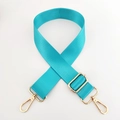 Close-up of turquoise nylon bag strap with polished gold-tone metal lobster clasps - Aqua Blue