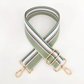 Detail eines verstellbaren breiten gestreiften Segeltuch-Taschenriemens mit Goldkarabiner - Matcha-Grün