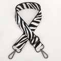 Macro view of zebra pattern canvas bag strap with gunmetal swivel hooks and adjustable buckle - White With Gunmetal Buckle