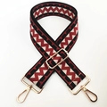 Close-up of wide adjustable woven bag strap with red and black geometric wave pattern - Silver Clasp / Black with Brick Red
