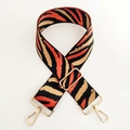 Macro shot of colorful tiger pattern nylon strap with polished golden metal buckles - Orange
