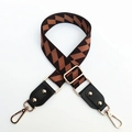 Dettaglio tracolla per borsa con motivi geometrici, ganci dorati e finiture in pelle - Cinturino Caffè + Pelle Nera