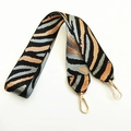 Detail of a wide zebra pattern shoulder strap with golden lobster clasps for bags - Gray